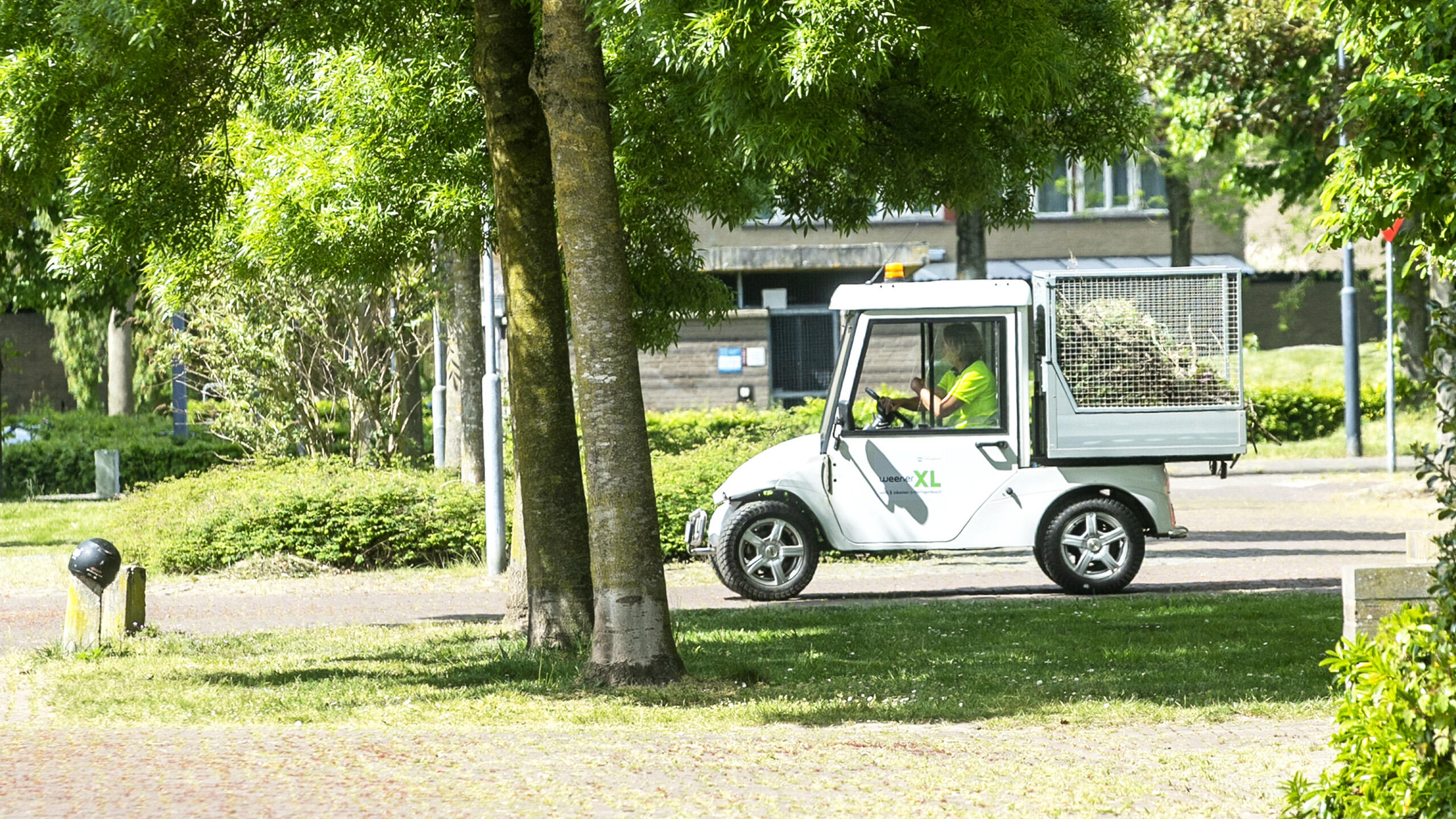 Medewerker groen van WeenerXL met groen wagen.